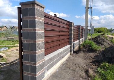 Забор из металлоштакетника с горизонтальной зашивкой и бетонными столбами